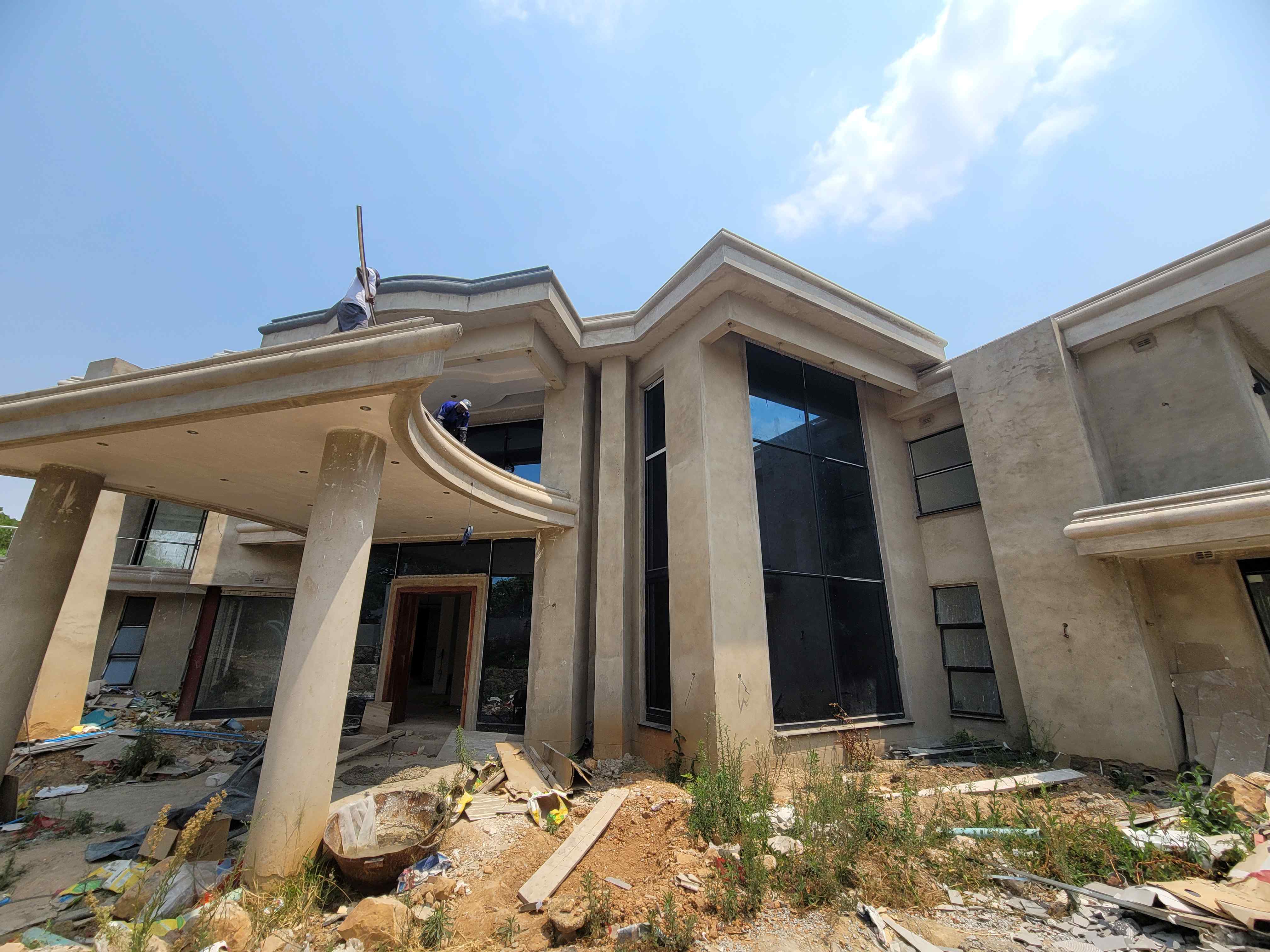 Luxury residence with glass facade under construction by Martcosy Construction